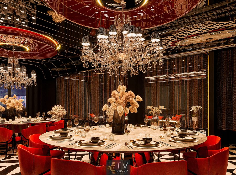 Phòng VIP nhà hàng sang trọng với bàn tròn đá marble, ghế nhung đỏ cao cấp, đèn chùm pha lê lớn, trần gương nghệ thuật và ánh sáng vàng ấm tạo không gian ẩm thực riêng tư, đẳng cấp. 