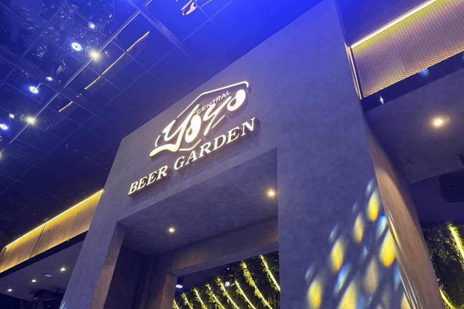 Cổng vào nhà hàng YOYO Beer Garden – thiết kế thi công hiện đại tại Hồ Con Rùa TP.HCM, nổi bật với logo phát sáng và chất liệu bê tông thô sang trọng