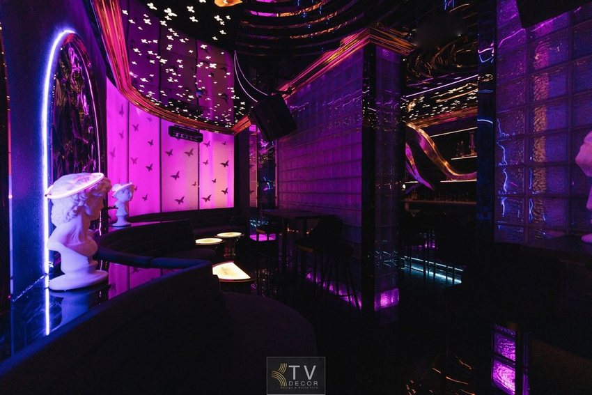 Không gian cafe nghệ thuật với ánh sáng tím huyền ảo và decor tượng cổ ấn tượng – thiết kế bởi KTV Decor.