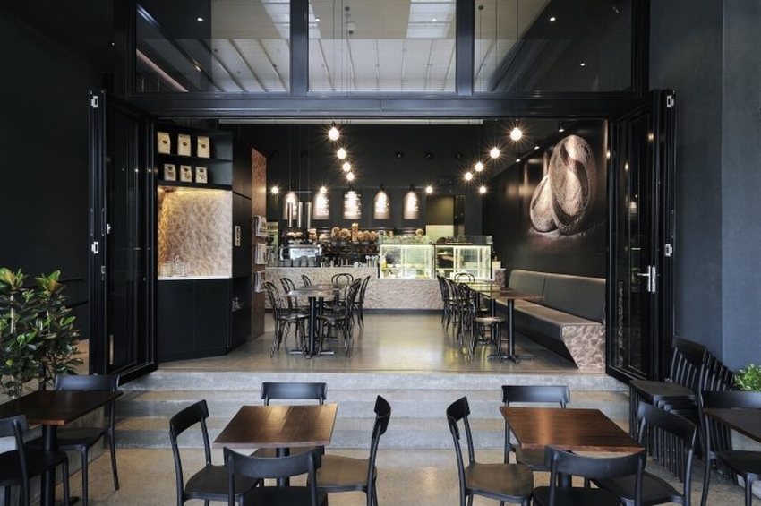 Quán cafe thiết kế tối giản hiện đại, không gian mở thoáng đãng với tone đen chủ đạo, tạo cảm giác sang trọng và ấm cúng.