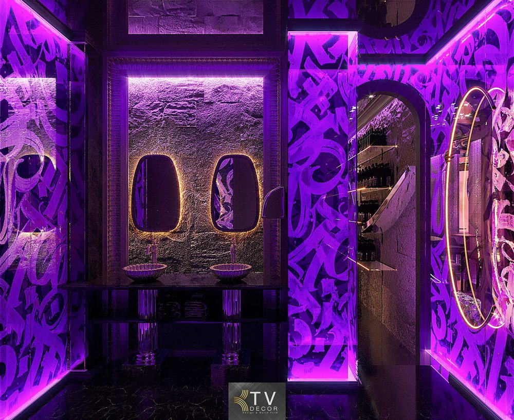 Thiết kế khu vực vệ sinh Lounge Nightlife diện tích nhỏ 100m² với ánh sáng tím nghệ thuật, hệ gương LED hiện đại và tường phủ họa tiết graffiti cá tính. Mẫu thiết kế đậm chất thương hiệu nightlife