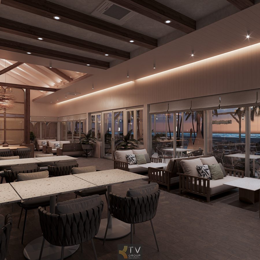 Không gian thư giãn nhìn ra bãi biển, nổi bật với ghế sofa mây, ánh đèn vàng nhẹ và khung cảnh dừa tạo cảm giác sang trọng.