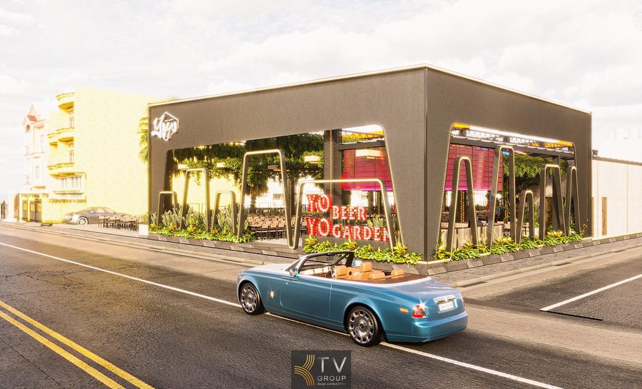 Không gian Beer Garden ngoài trời với dãy bàn gỗ dài, trần phủ cây xanh và hệ thống đèn LED nhiều màu tạo không khí sôi động, phù hợp tiệc đông người.