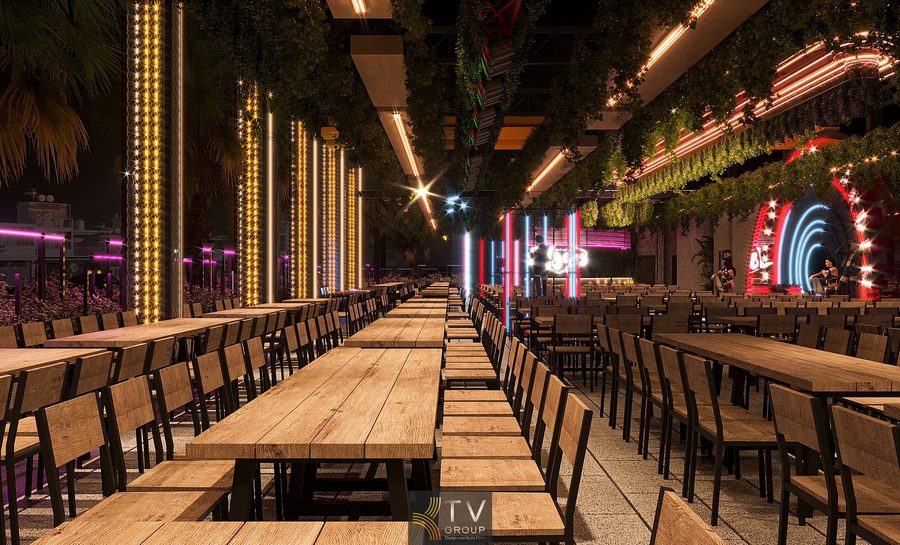 Thiết kế Beer Garden thoáng sáng với bàn gỗ dài, hệ thống đèn sân khấu nhiều màu và cây xanh treo mang lại trải nghiệm thư giãn độc đáo.
