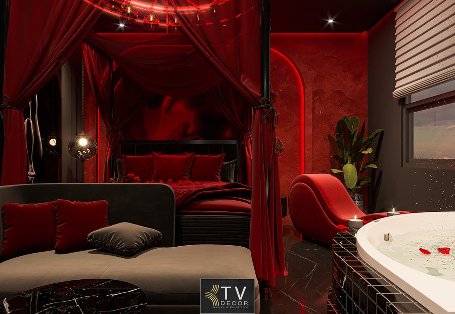 Nội thất phòng khách sạn lãng mạn gồm sofa đen đỏ, thảm tròn và đèn LED trần vòng độc đáo.