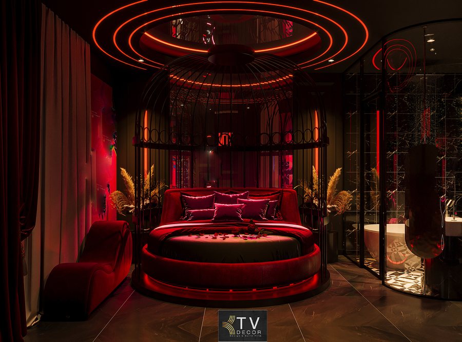 Không gian phòng khách sạn lãng mạn được thiết kế theo phong cách Romantic Luxury với giường tròn, ánh sáng LED đỏ và bố cục mềm mại cuốn hút. 