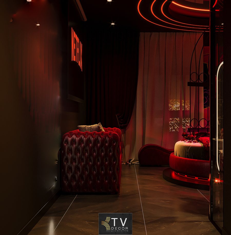 Không gian phòng nghỉ lãng mạn với ghế thư giãn đỏ, cây decor và bố cục ánh sáng tạo chiều sâu thẩm mỹ độc đáo. 