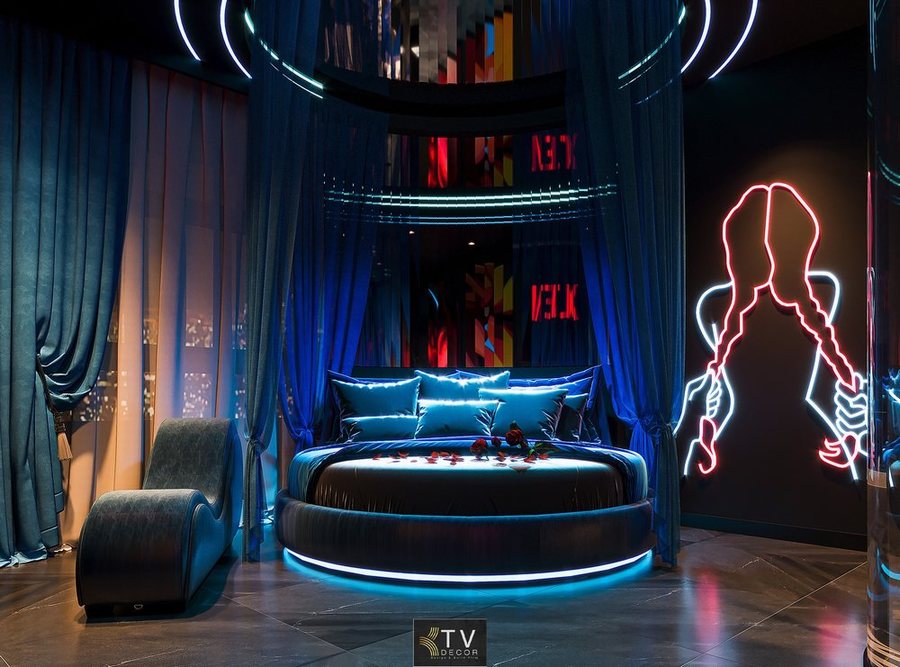 Thiết kế khách sạn tình yêu tại TP.HCM với giường tròn bọc nhung, ánh sáng LED xanh và tranh đèn neon nổi bật