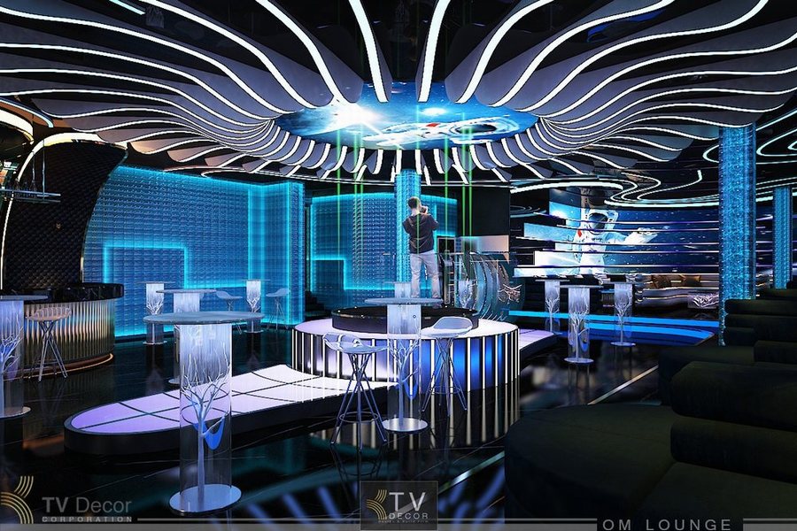 Không gian Lounge hiện đại với trần uốn lượn nghệ thuật, ánh sáng xanh bắt mắt và khu vực quầy bar trung tâm sang trọng – mang đến phong cách giải trí cao cấp, đầy cá tính.