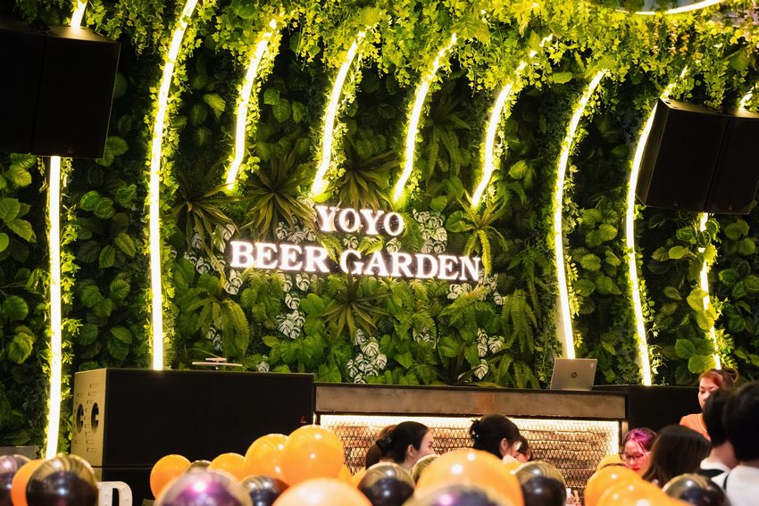 Thiết kế khu DJ và sân khấu tại YOYO Beer Garden với tường cây xanh kết hợp ánh sáng LED hiện đại, tạo điểm nhấn trong không gian Beer Food Garden tại TP.HCM.