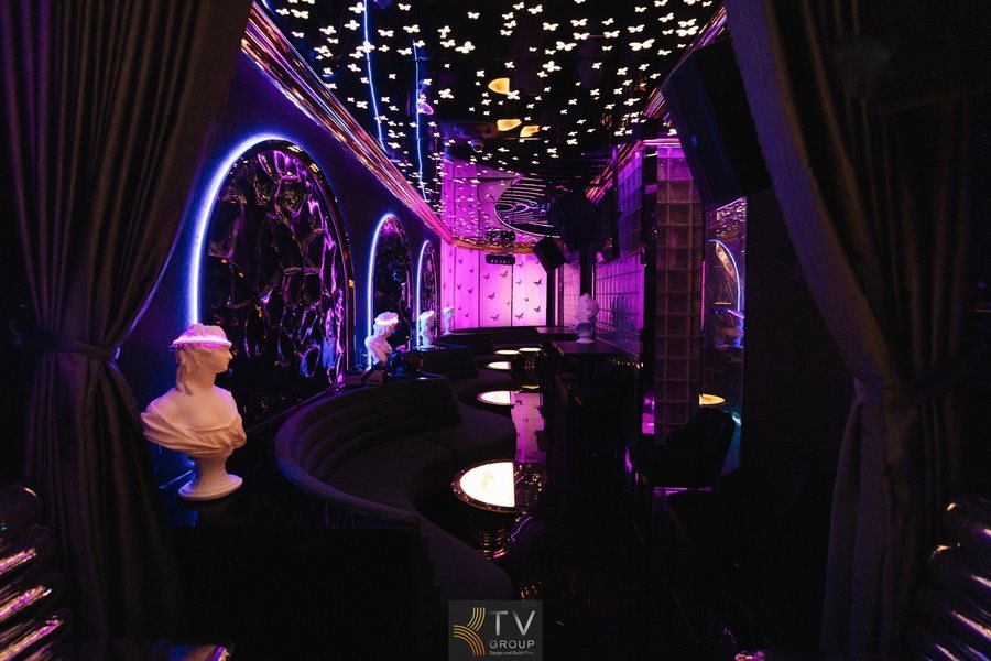 Concept lounge high-class với signature “dark art + neon violet” – xử lý trần LED bươm bướm – điểm xuyết sculpture trang trí – không gian booth cong – bàn tiệc ánh sáng xoay vòng. Thiết kế hướng trải nghiệm gần – riêng tư – tinh tế như gallery nghệ thuật về đêm – đúng chất nightlife sang trọng và khác biệt.
