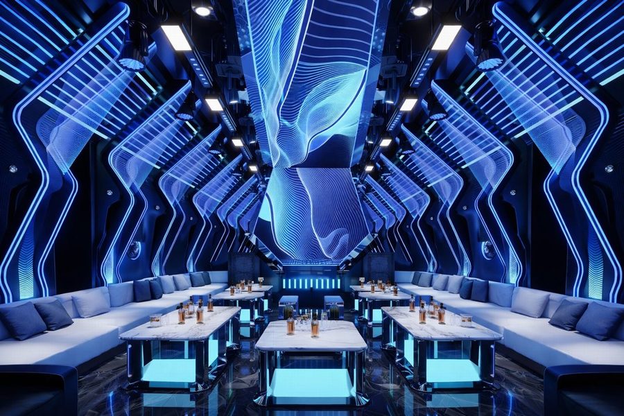 Phòng karaoke H KTV phong cách futuristic với ánh sáng LED xanh, trần uốn lượn nghệ thuật, nội thất sofa cao cấp và bàn đá hiện đại, tạo không gian giải trí ấn tượng