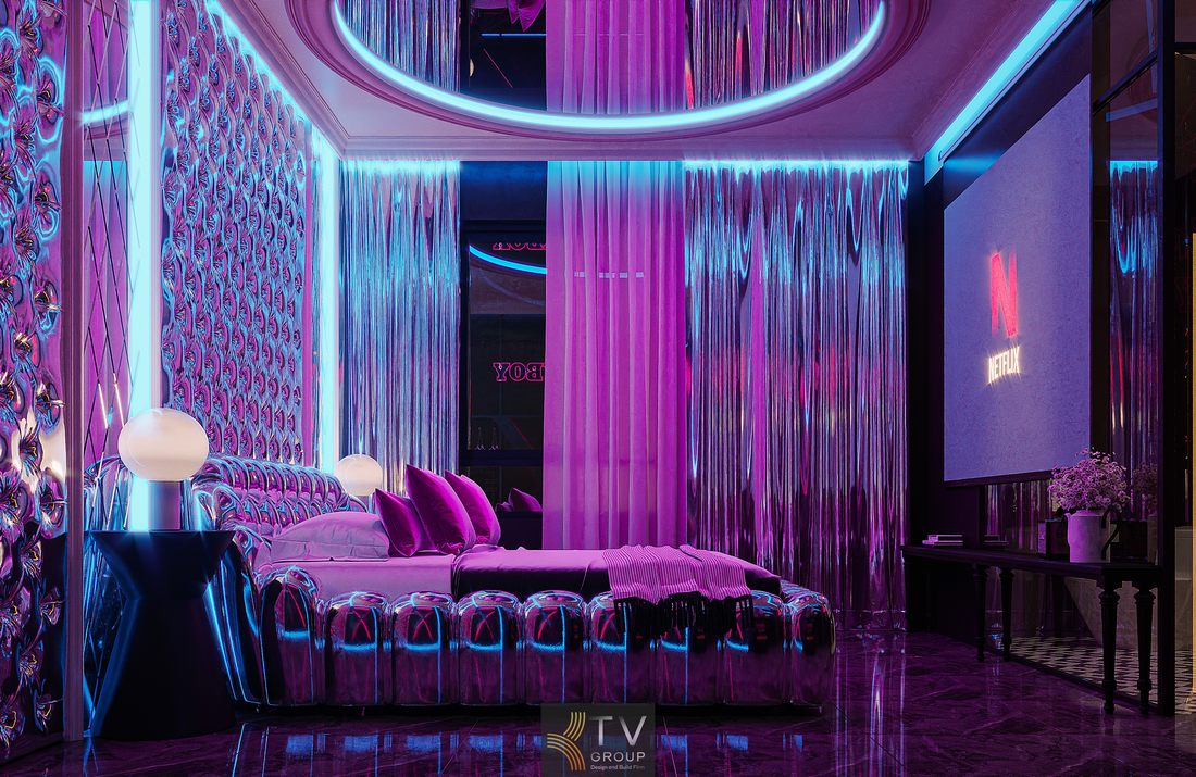 Không gian phòng khách sạn sử dụng hệ đèn LED đa màu kết hợp vật liệu kim loại phản chiếu, giường trung tâm thiết kế độc đáo và rèm ánh kim tạo hiệu ứng ánh sáng chuyển động thu hút người nhìn.