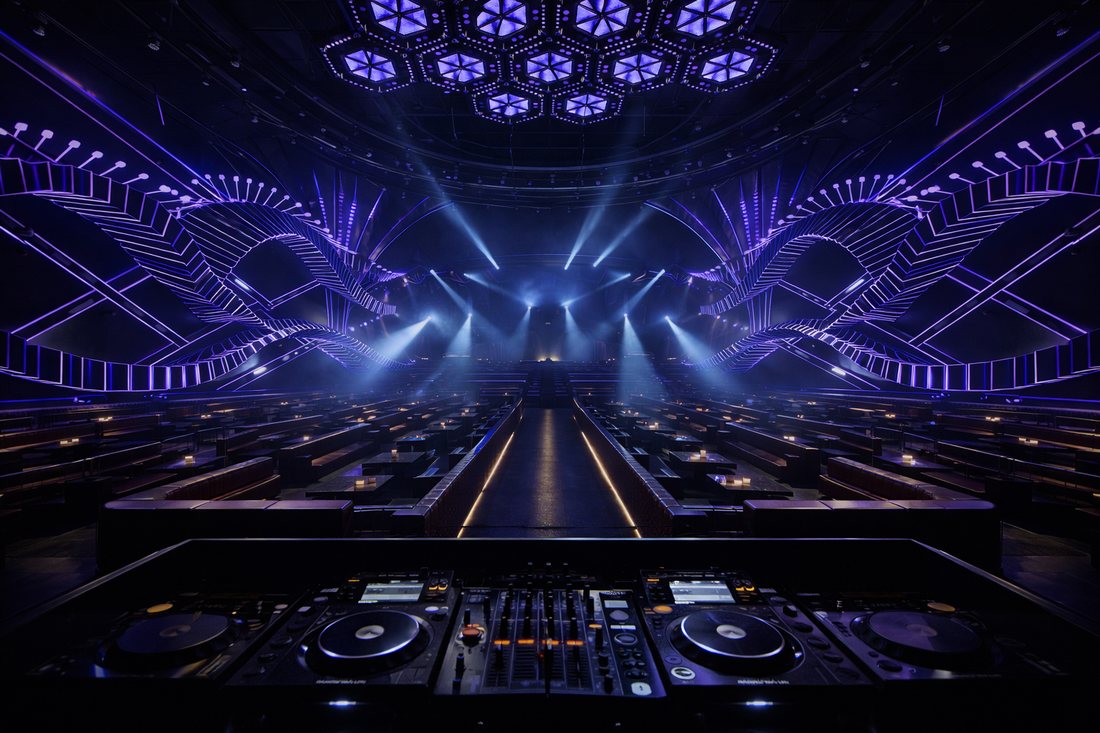 Thiết kế bar EDM hiện đại với sân khấu trung tâm, ánh sáng LED xanh tím, trần module hình học, không gian rộng 700–900m², phong cách nightclub cao cấp. 