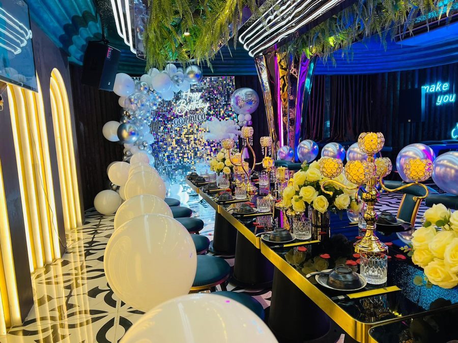 Thiết kế nhà hàng với trần ánh kim và hệ thống LED line tạo hiệu ứng ánh sáng sang trọng và thu hút Khu vực quầy bar nhà hàng với thiết kế hiện đại, ánh sáng xanh tím nổi bật và nội thất cao cấp