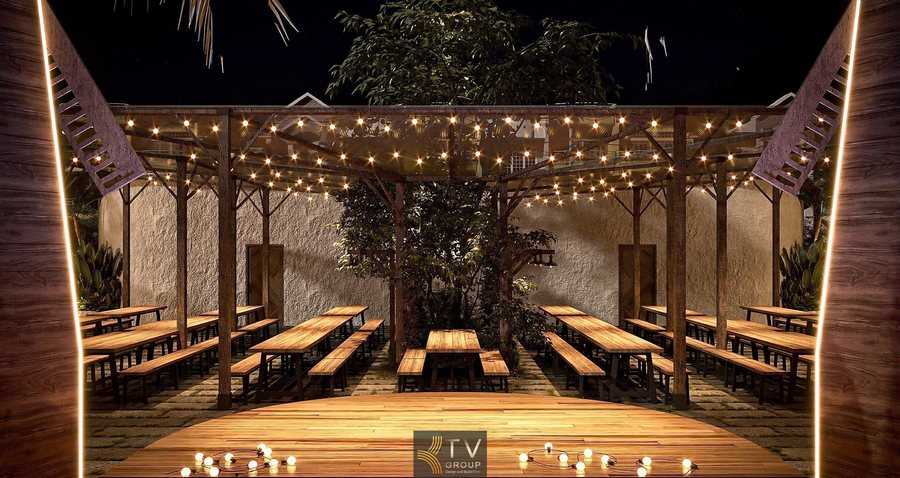 “Không gian ăn uống ngoài trời thoáng đãng với ánh sáng vàng ấm.”  “Nhà hàng sân vườn phong cách mộc với bàn gỗ dài và đèn treo.” 