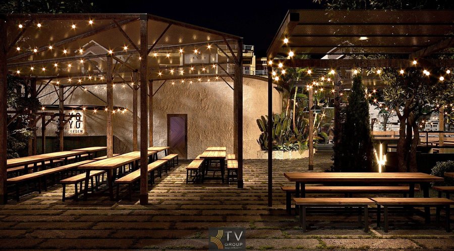 “Khuôn viên nhà hàng về đêm với hàng ghế gỗ và cây xanh xung quanh.”  “Không gian ẩm thực ngoài trời mang phong cách mộc mạc, thoáng đãng.” 