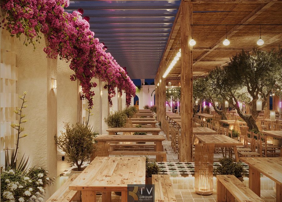 Thiết kế Beer Garden ban đêm lãng mạn. Ánh sáng vàng rực rỡ, cây xanh lớn, sàn gạch họa tiết. 