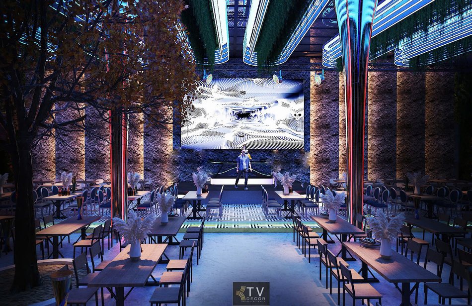 Khu vực sân khấu Beer Garden với bố trí tường đá thô và đèn LED.  Cột kim loại phát sáng chạy dọc không gian Beer Garden hiện đại.  Không gian thư giãn Beer Garden với ánh sáng nghệ thuật.  Dãy bàn ghế Beer Garden kết hợp ánh sáng trần xanh lam. 