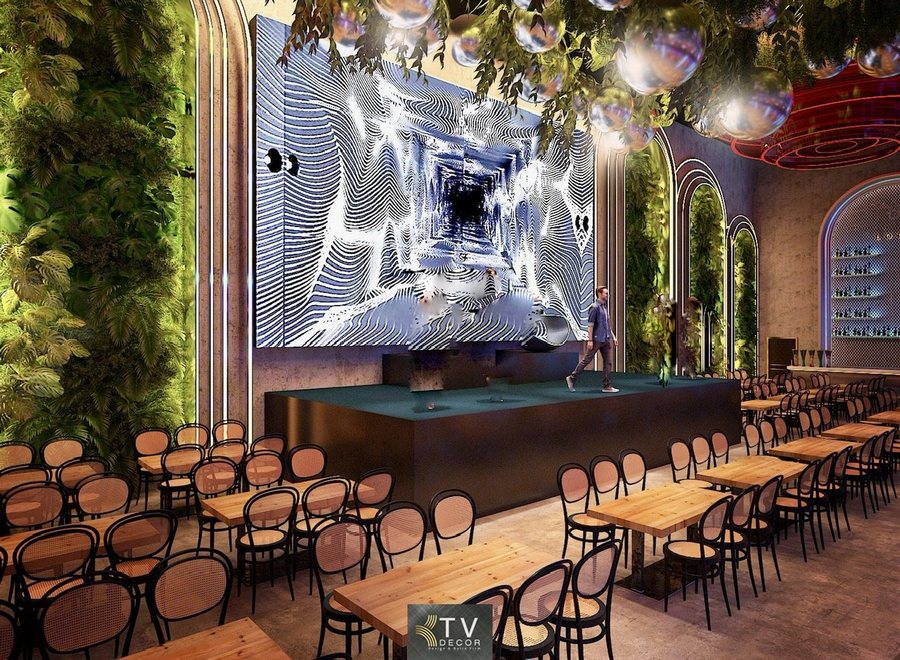 Không gian Beer Garden nổi bật với sân khấu lớn LED ấn tượng, hiệu ứng thị giác cuốn hút và hệ tường cây xanh mang lại cảm giác tươi mát. Bàn ghế gỗ mộc kết hợp ánh sáng ấm – lạnh hài hòa tạo nên một không gian giải trí hiện đại, rộng thoáng và đầy năng lượng. 